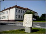 Znak obce Lužice před OÚ - v pozadí budova ZŠ Znak obce Lužice před OÚ - v pozadí budova ZŠ
